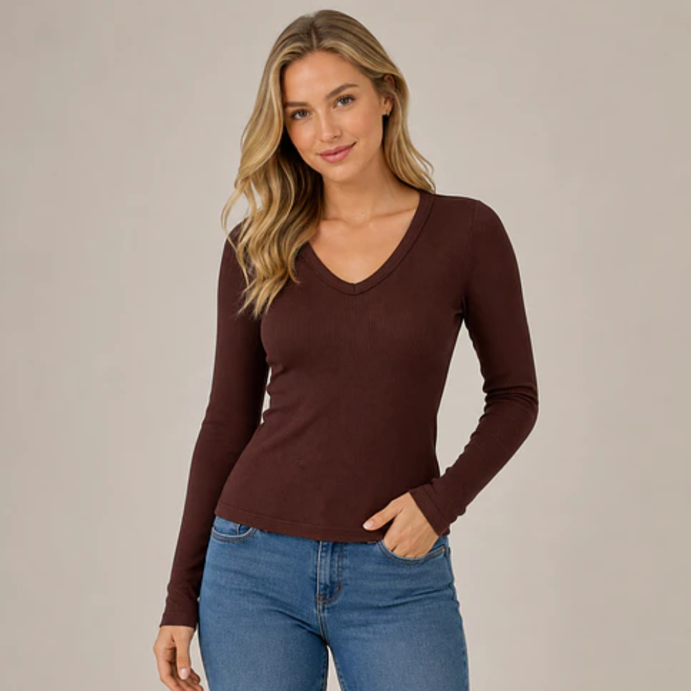 Mujer usando polera café acanalada de manga larga y escote V, cuerpo completo.